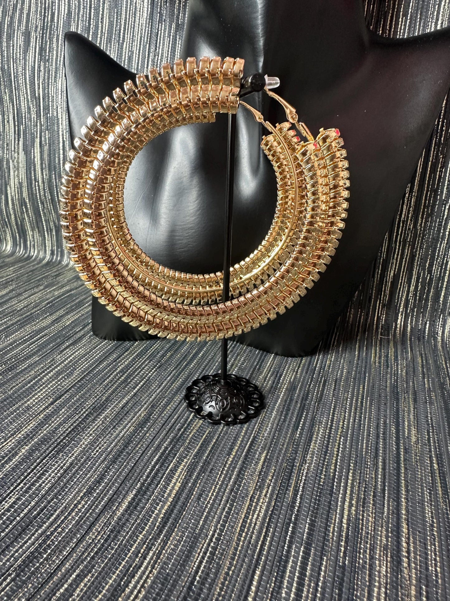 Large Patterned gold hoop earrings.