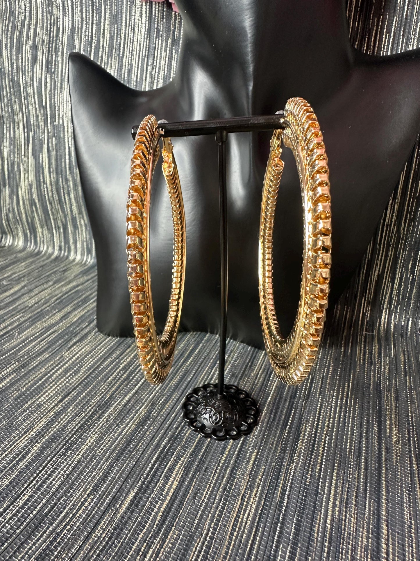 Large Patterned gold hoop earrings.