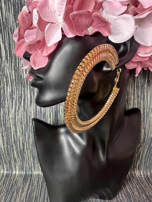 Large Patterned gold hoop earrings.